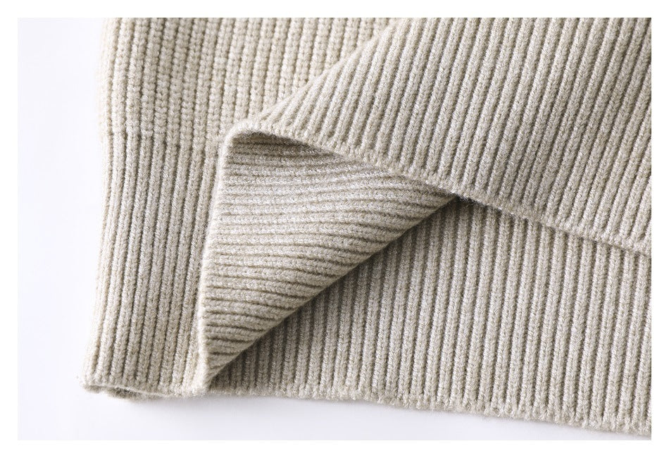 Close-up of the cream ribbed knit sweater's folded hem and side seam.