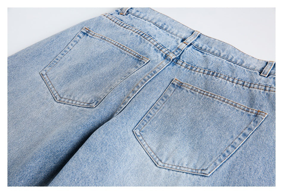 Close-up rear view of light blue jeans showing two back pockets, waistband and belt loops.