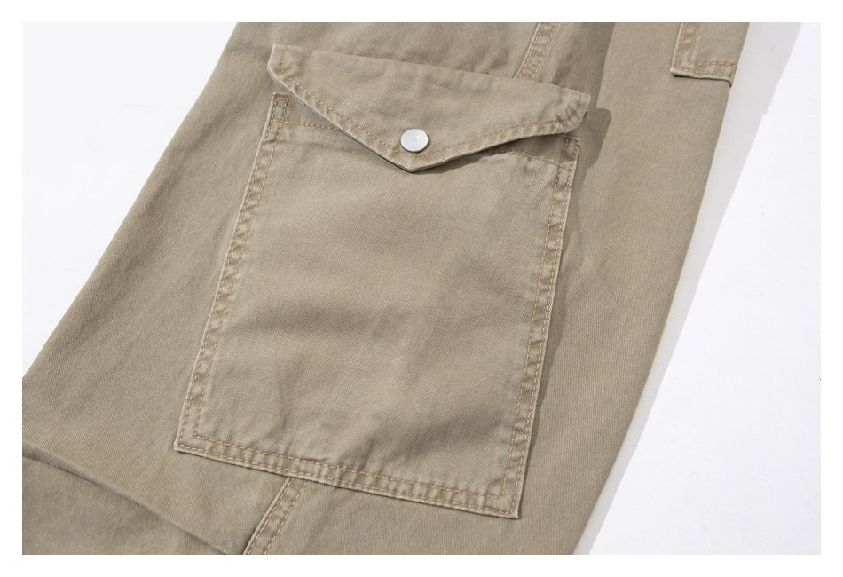 Close-up of a large beige cargo pocket with a pointed flap and silver snap button.
