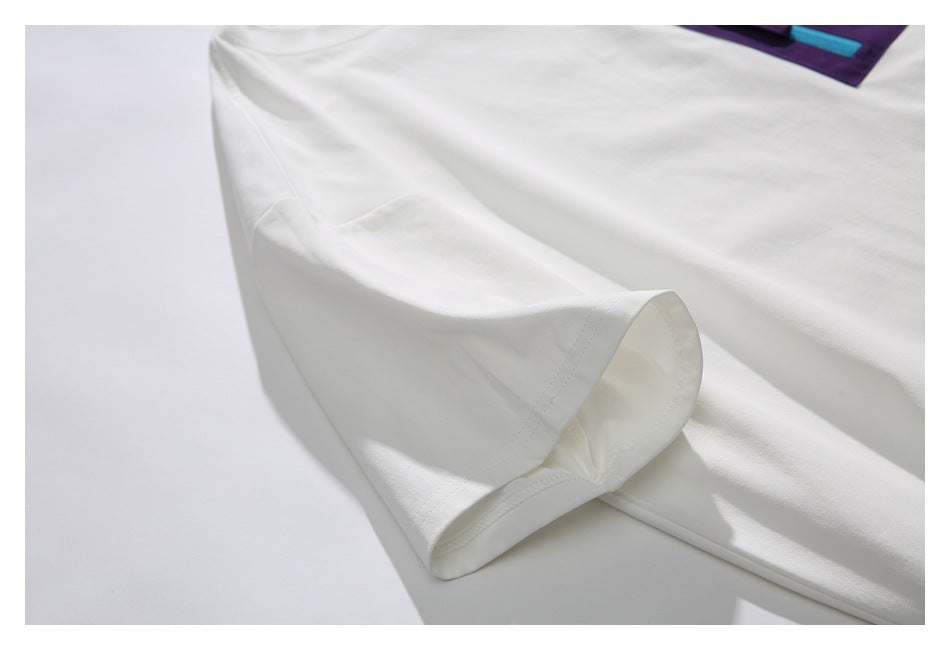 Close-up of a white short sleeve, showing the stitched sleeve opening and a glimpse of a purple pocket.