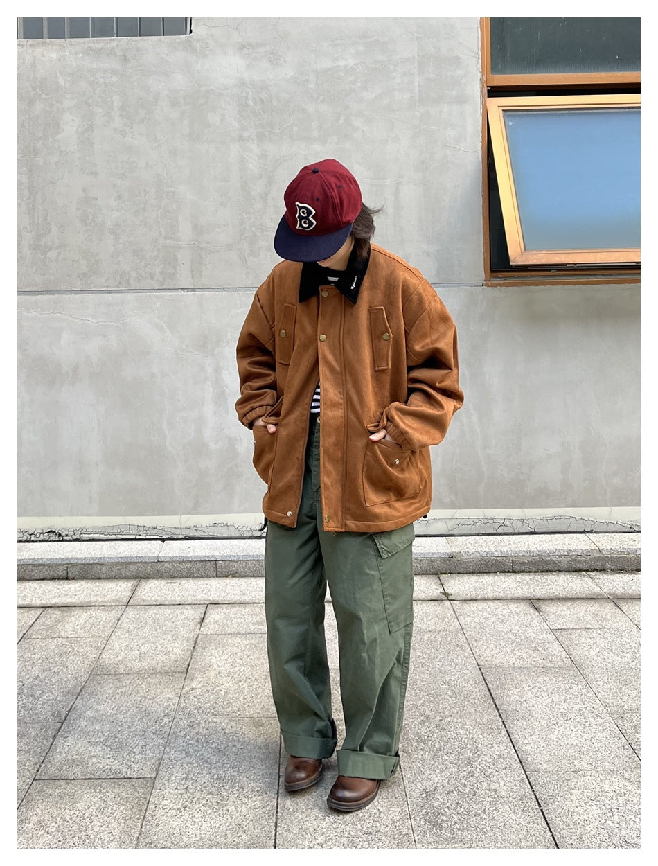 Person wearing a khaki-brown suede-look jacket with black collar over green cargo pants and a maroon cap, front view