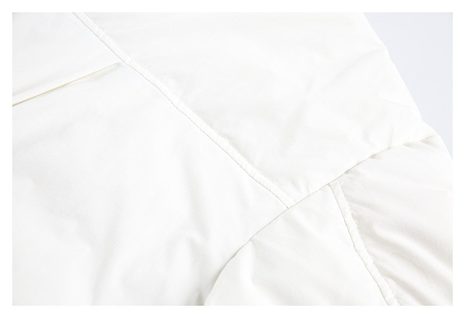 Close-up of intersecting stitched seams on a white garment.