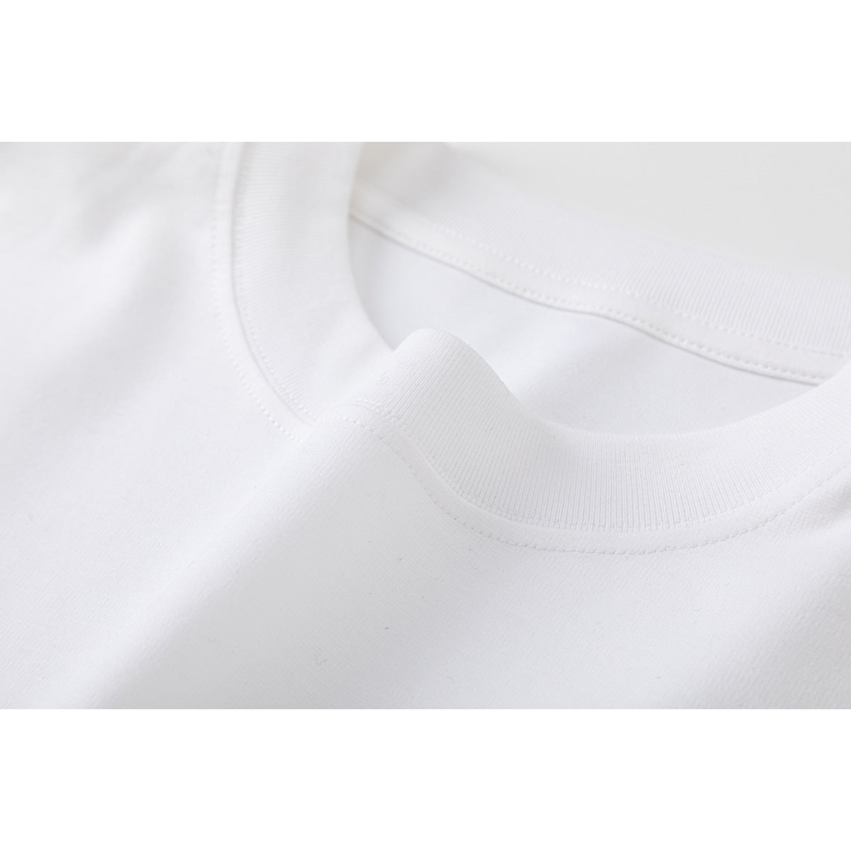 Close-up of the white shirt's ribbed crew neckline and stitching.