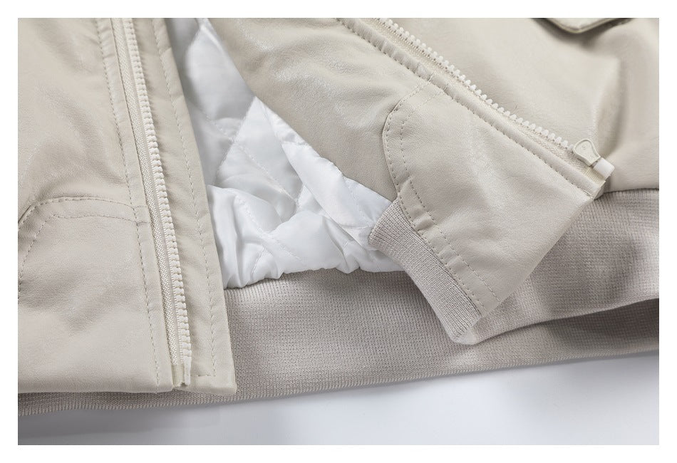 Close-up of a light beige jacket showing the open front zipper, white lining, and ribbed hem.