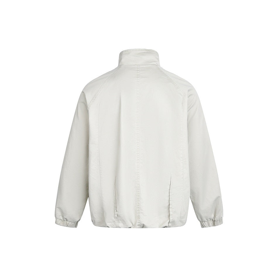 Back view of a white jacket with a stand collar, raglan sleeves, seam detailing, and elastic cuffs.
