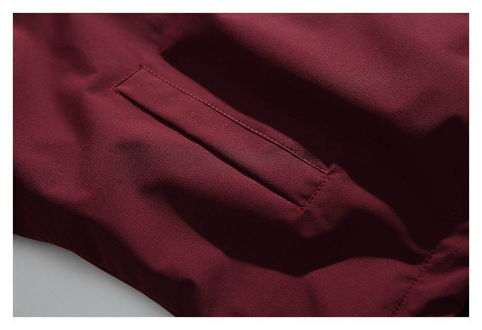 Close-up of a narrow angled pocket opening on the burgundy jacket.
