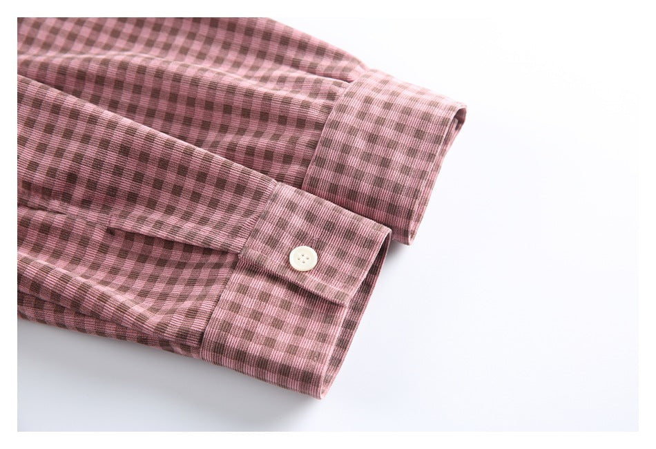 Close-up of the checked shirt's buttoned sleeve cuff and folded sleeve.