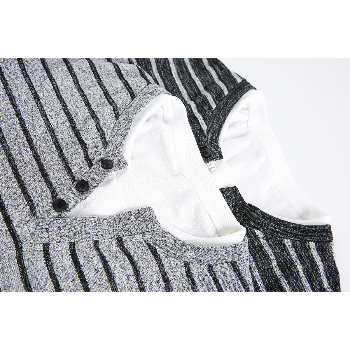 Close-up of gray and charcoal striped tops showing white neck trim and black buttons.