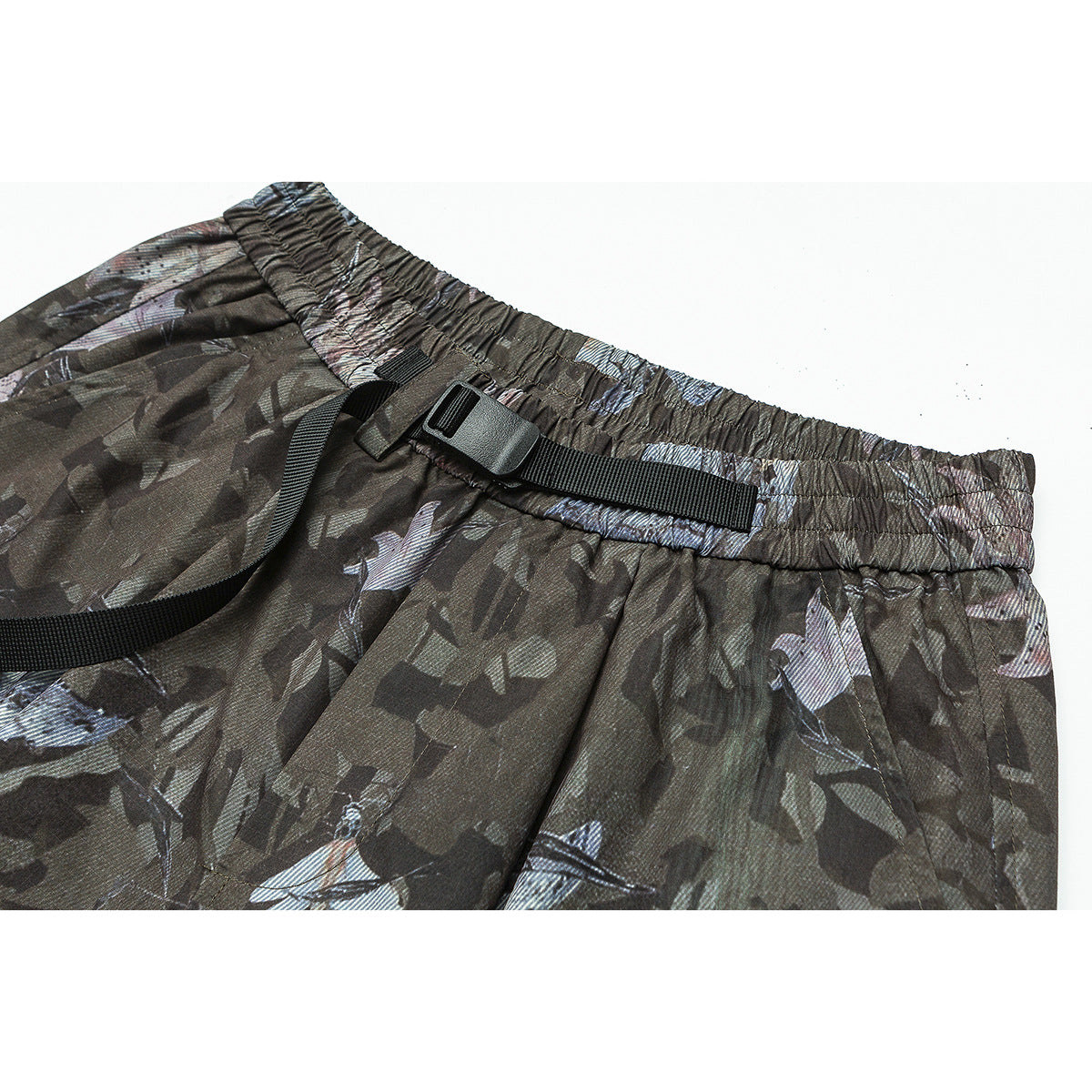 Close-up of dark camouflage-print pants with an elastic waistband and black adjustable webbing belt.