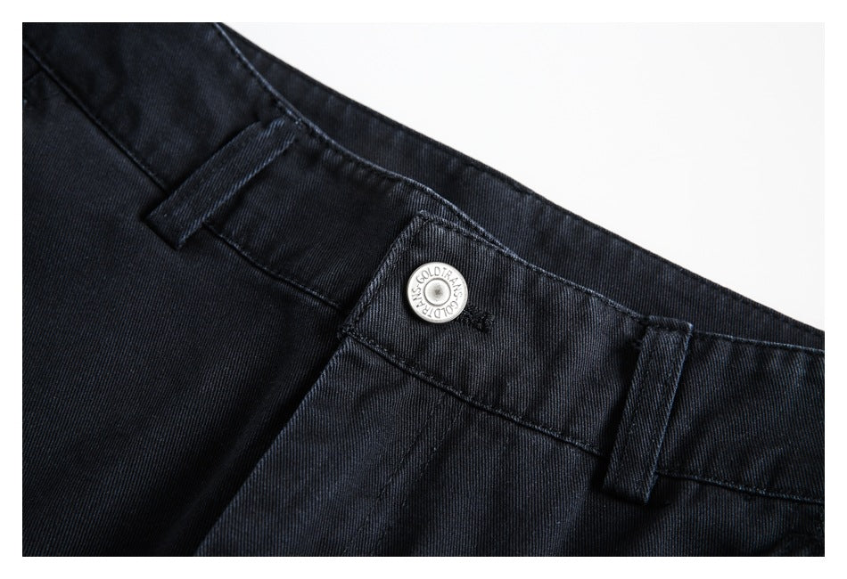 Close-up of black trousers showing the waistband, belt loops, and a silver button.