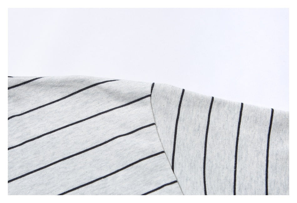 Close-up of a light gray T-shirt’s shoulder and short sleeve with thin dark stripes.