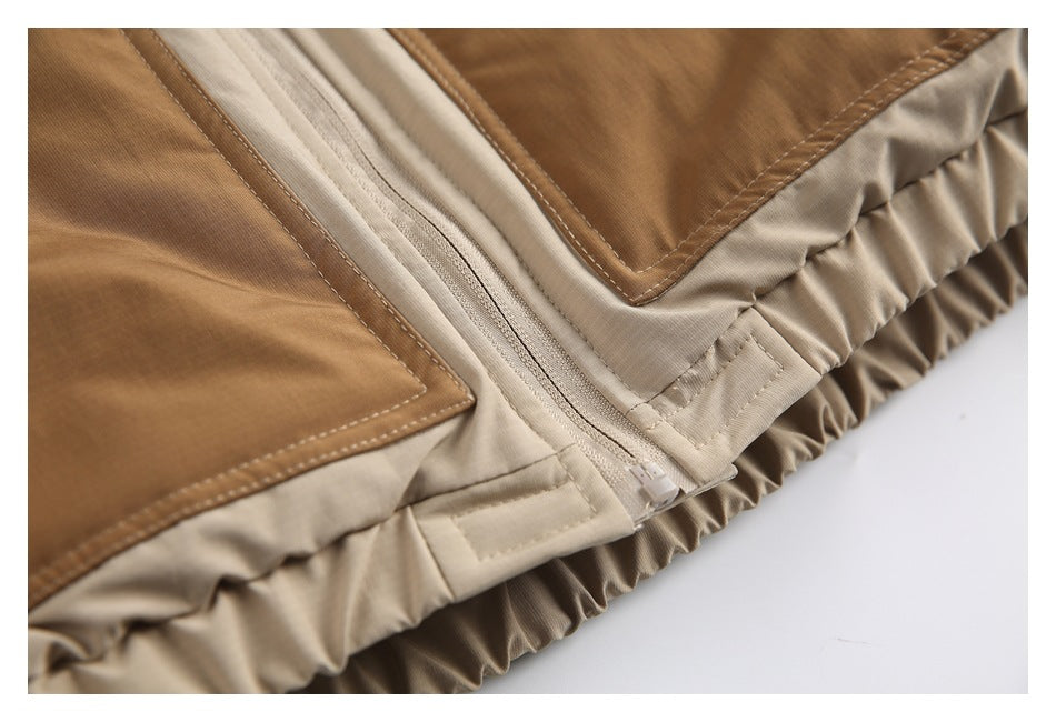 Close-up of the jacket's front zipper, stitched tan panels, and gathered hem.