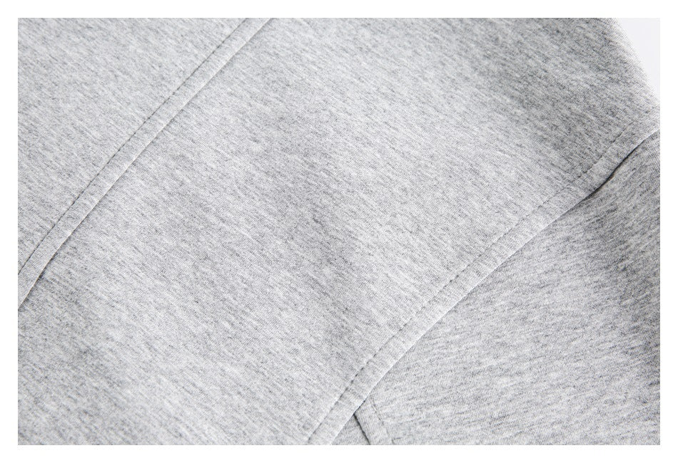 Close-up of heather-gray fabric with curved stitched seams and panel construction.
