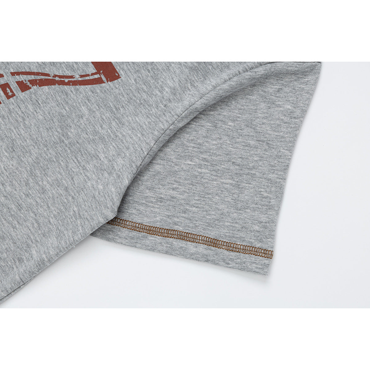 Close-up of a gray T-shirt sleeve with brown contrast stitching and part of the front graphic.