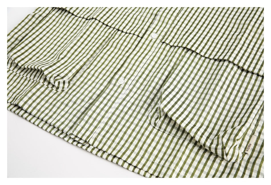 Olive-and-white checked button-up shirt laid flat, showing its front, buttons, and chest pocket.