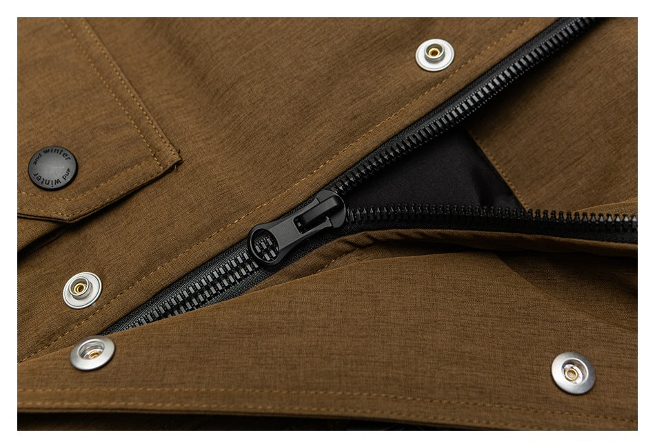 Close-up of the brown jacket's black zipper beneath a snap-button storm flap.