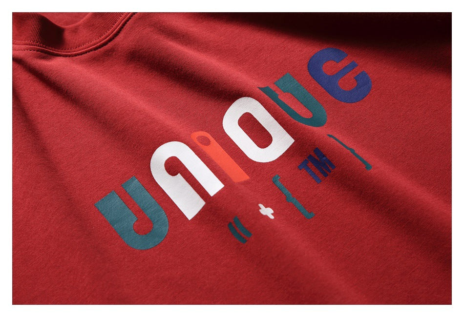 Close-up of a red T-shirt with a multicolored graphic print across the chest.