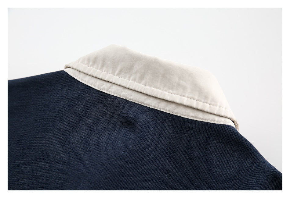 Close-up of a cream pointed collar against dark navy garment fabric.