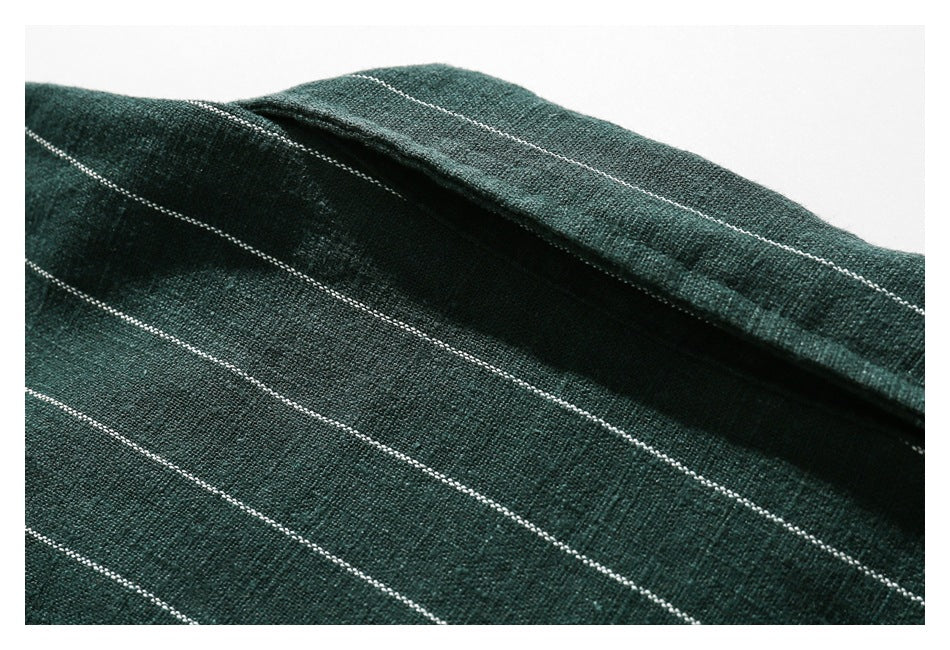 Close-up showing the dark green shirt's white pinstripes and textured fabric surface.