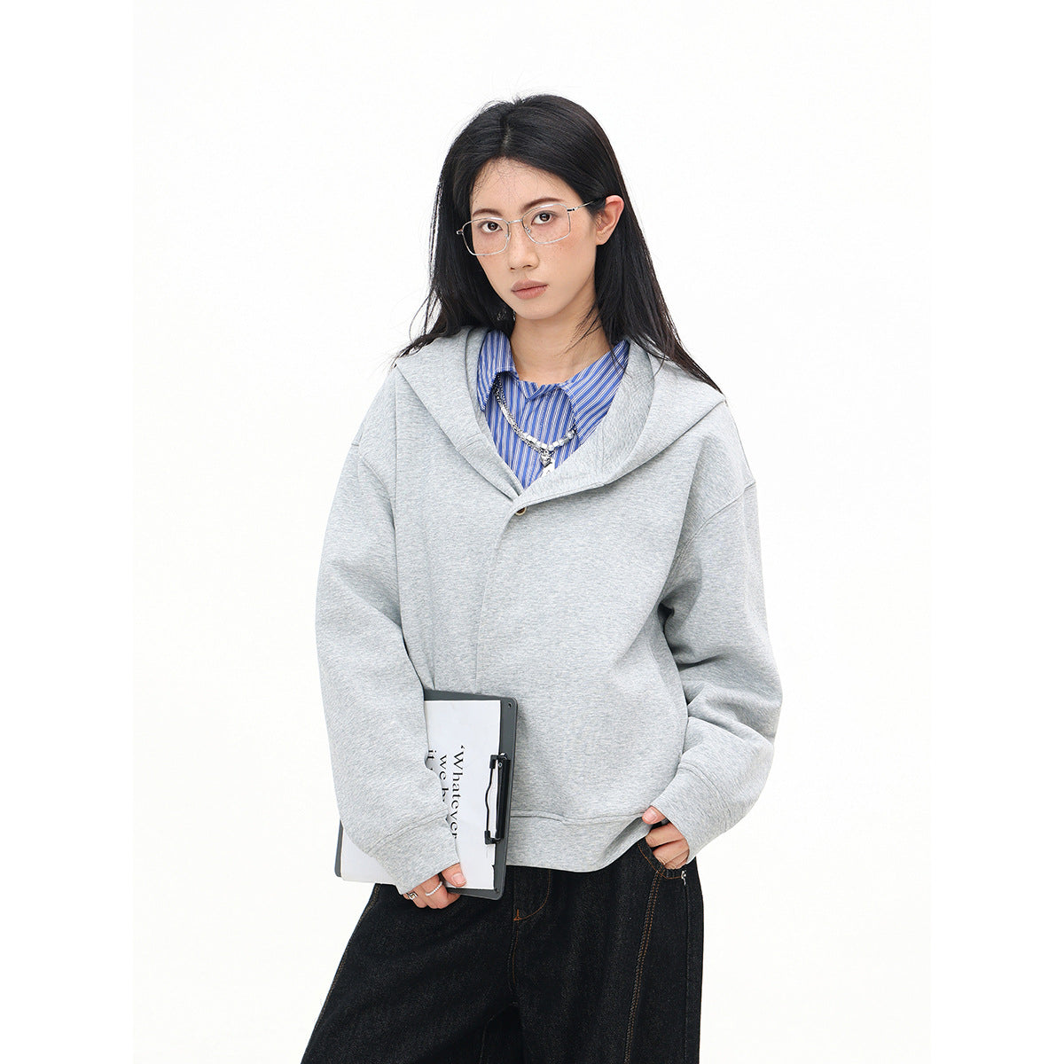 Model wearing a light gray oversized hooded sweatshirt with a wide folded collar and dark wide-leg jeans.