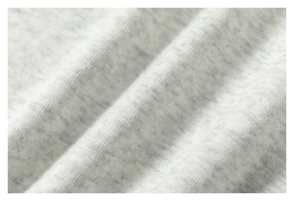 Close-up showing the mottled texture of light gray heather knit fabric.