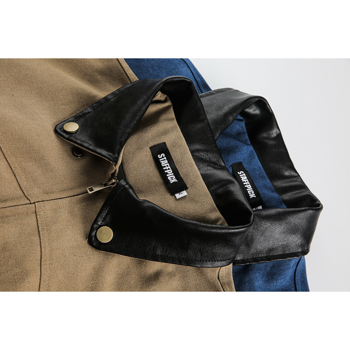 Close-up of tan and blue jackets showing black collars, brass snaps, zippers, and sewn-in labels.