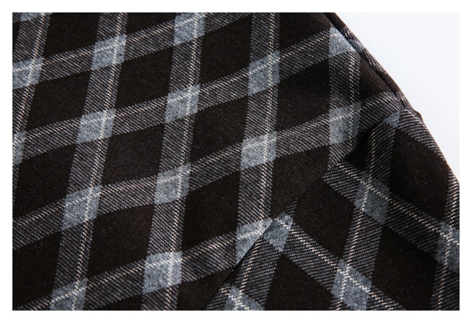 Close-up of dark fabric with a gray plaid pattern and a curved seam.