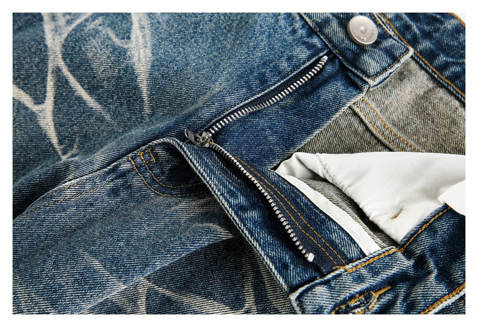 Close-up of the jeans' open fly, zipper, button, and light-colored inner lining.