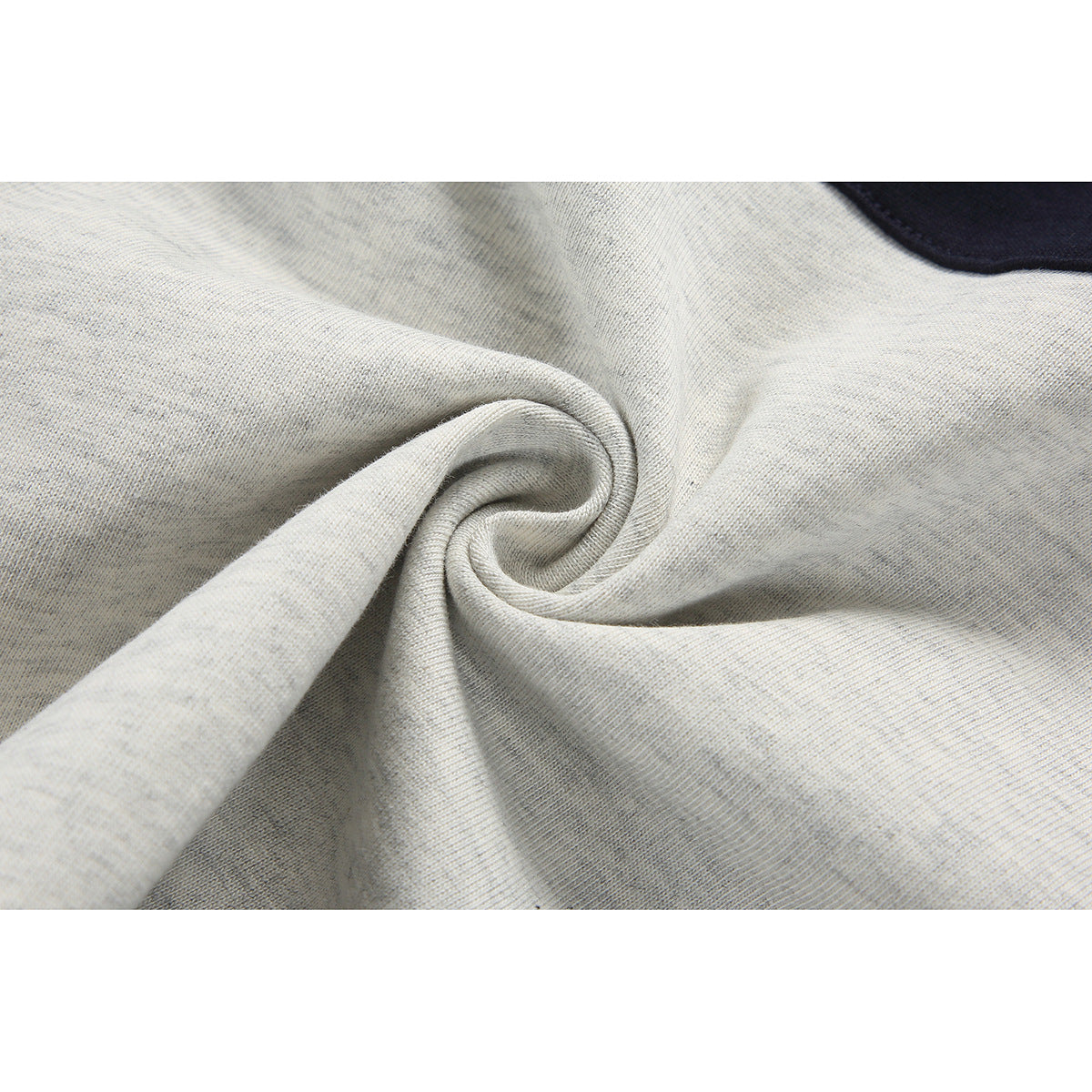Close-up of light gray fabric gathered into a twist, with a small navy section at the edge.