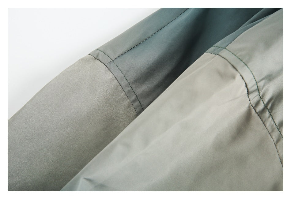 Close-up of stitched joins between teal and light gray garment panels.
