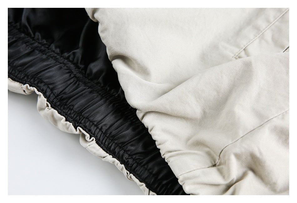 Close-up of cream fabric gathered along a black elastic waistband.