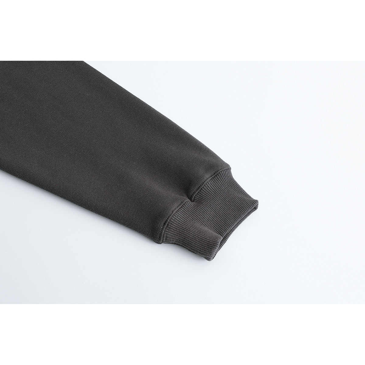 Close-up of a charcoal sleeve ending in a ribbed cuff.
