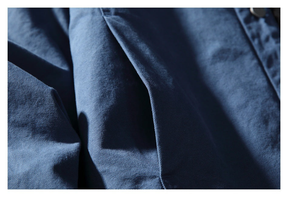 Close-up of dark blue garment fabric showing its woven texture and soft folds.