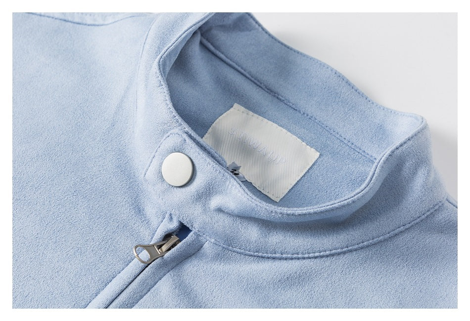 Close-up of a pale blue garment collar with a white snap, zipper pull, and inner label.