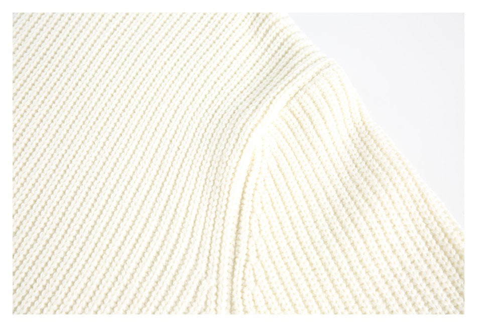 Close-up of the cream sweater’s textured knit and shoulder seam.