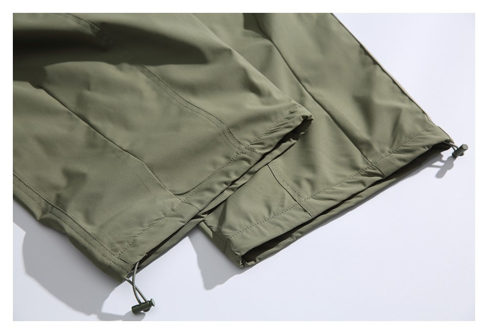 Olive-green garment hem with stitched panels and adjustable drawcord toggles.