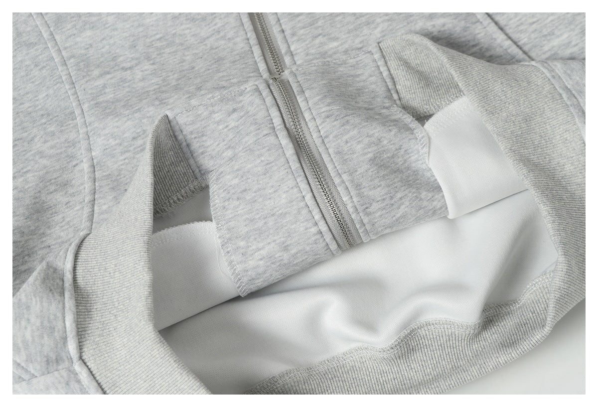 Close-up of the jacket's front zipper and ribbed hem, with the garment opened to show its inside.