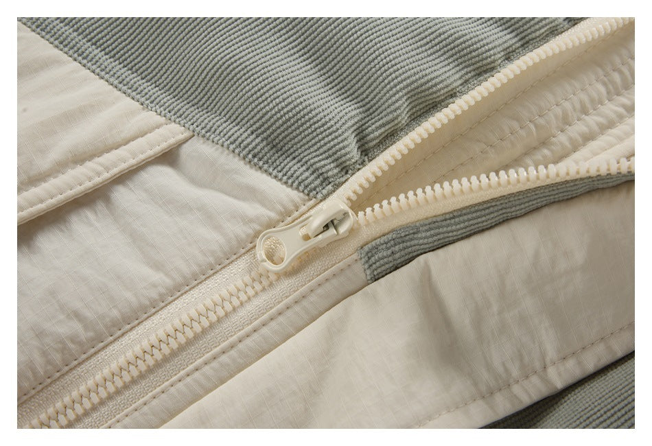 Close-up of a cream zipper and matching panels beside gray ribbed fabric.