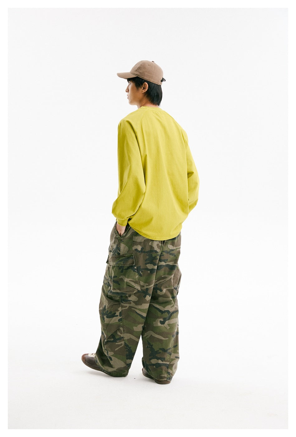 Back view of a model wearing a bright yellow-green oversized long-sleeve raglan shirt.