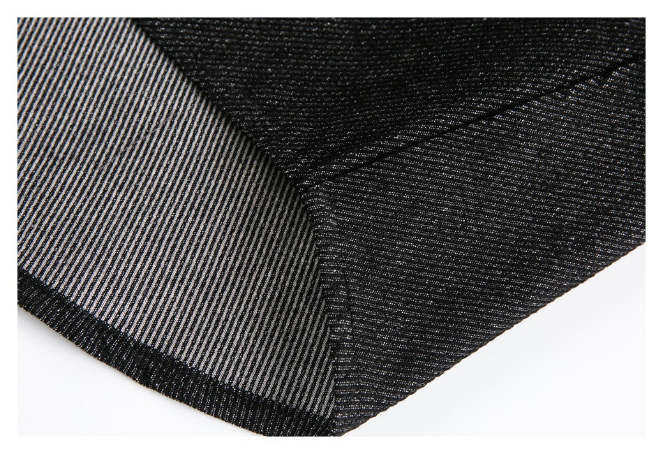 Close-up of black denim turned back to reveal its light-and-dark striped underside and seam.