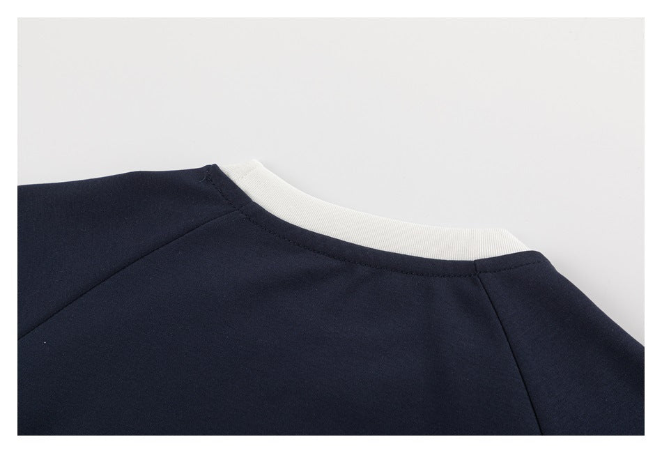 Close-up of a navy garment neckline with white ribbed trim and visible shoulder seams.