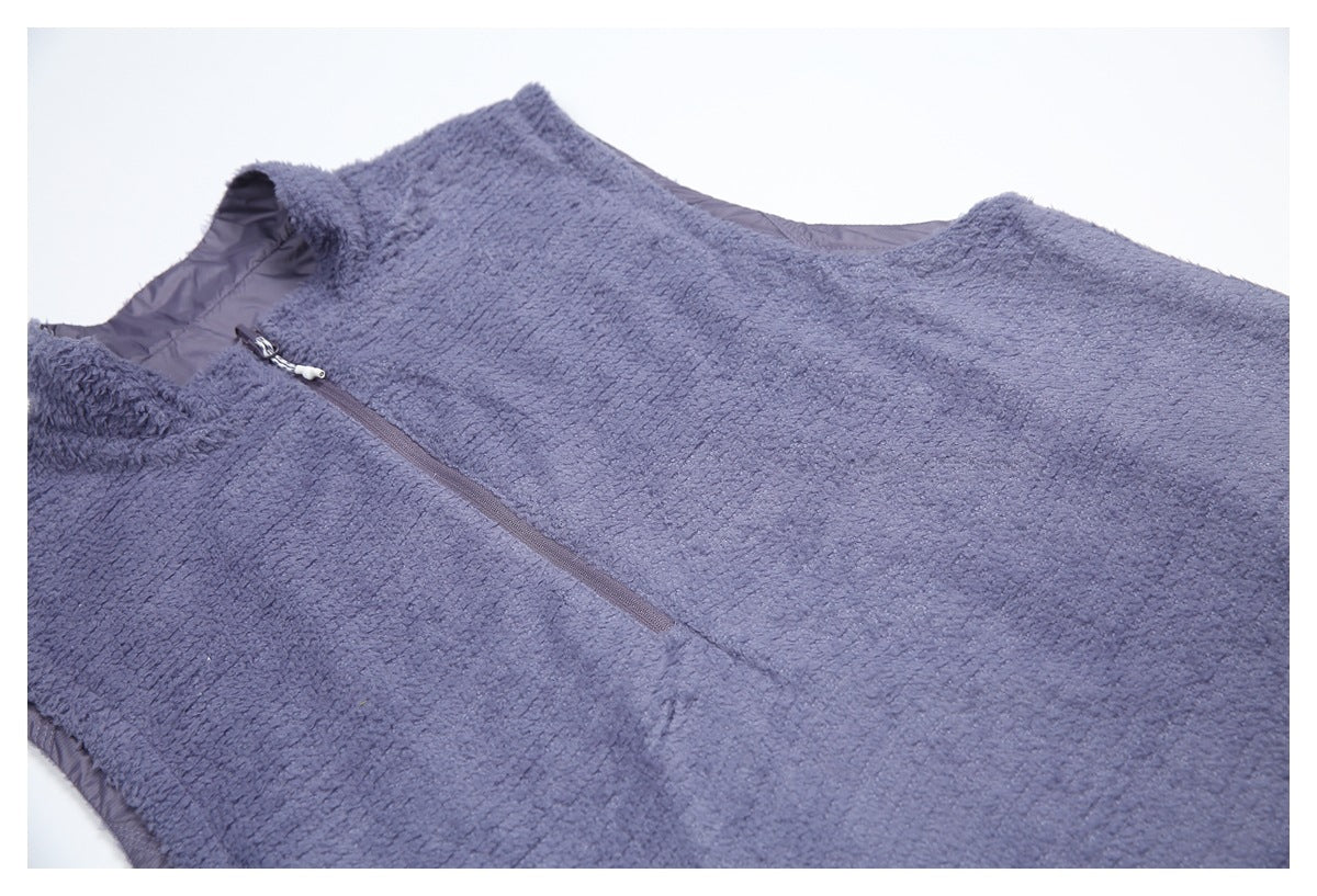 Close-up of a blue-gray fuzzy sleeveless garment with a quarter-length front zipper.