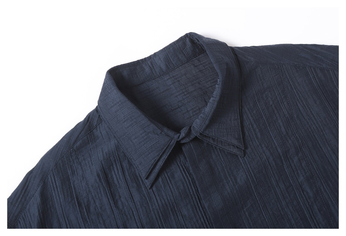 Close-up of the navy shirt's pointed collar and textured fabric.
