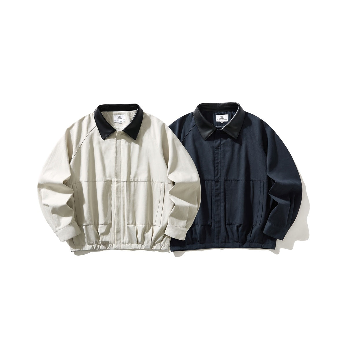 Two jackets displayed front-facing: ivory and dark navy, each with a black collar, long sleeves, and front pockets.