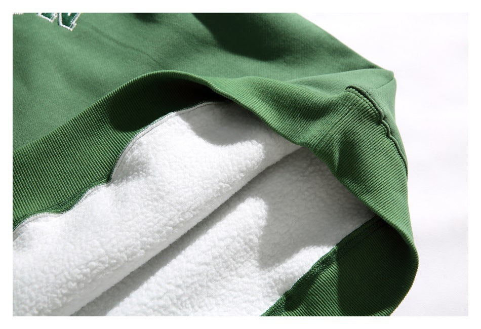 Close-up of a green sweatshirt turned back to show its thick white lining and ribbed edge.