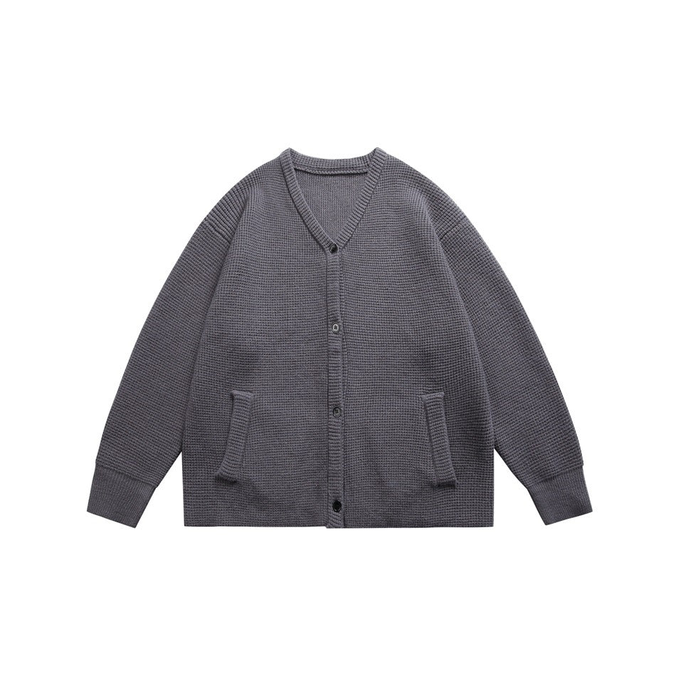Dark gray waffle-knit V-neck button cardigan with front pockets and ribbed cuffs, flat lay front view