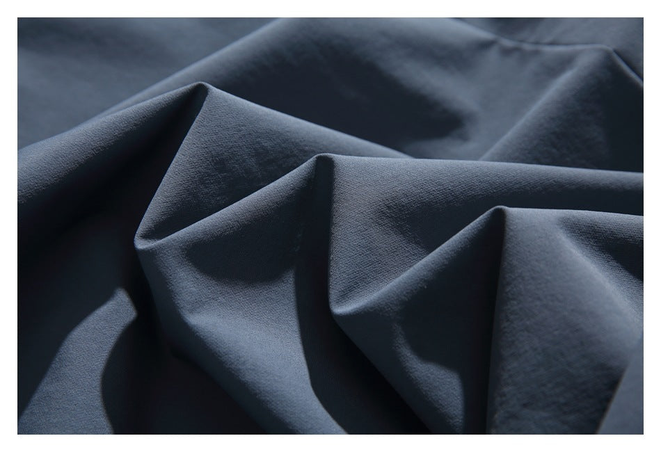 Close-up of dark navy fabric arranged in soft folds, showing its fine textured surface.