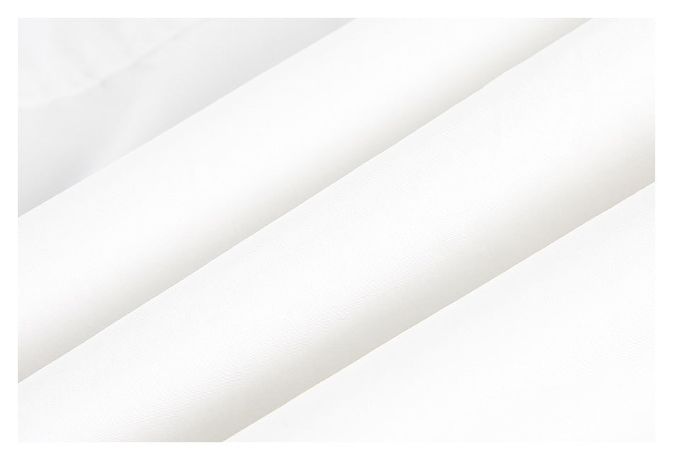Close-up of white fabric arranged in overlapping diagonal folds, showing a fine surface texture.