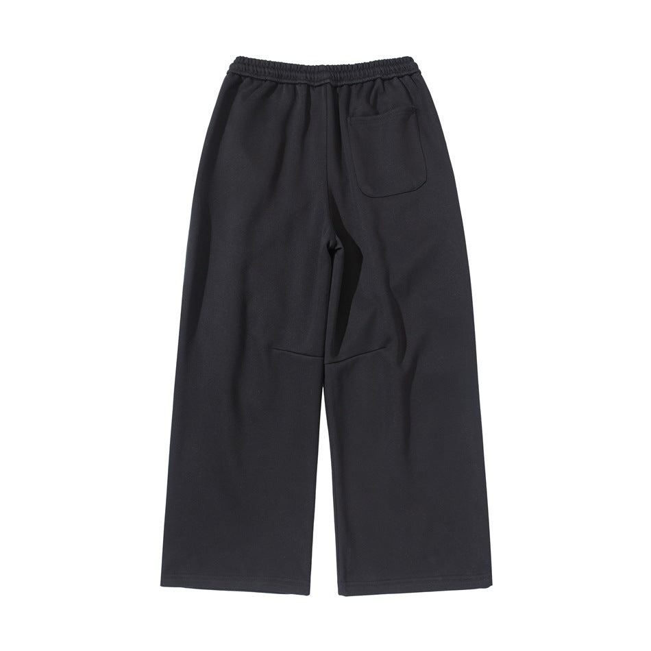 Back view of black wide-leg sweatpants with an elastic waistband and a single patch pocket.