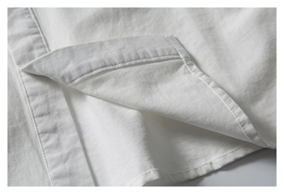 Close-up of a white garment showing a folded edge and neat stitching.